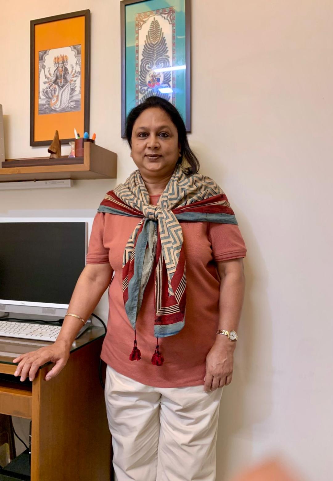 Sumedha Goel standing beside her desk